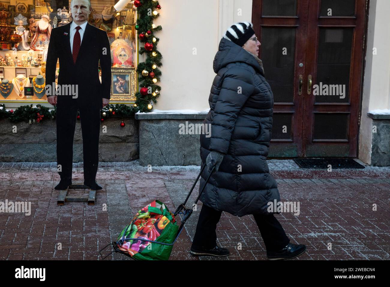 Moscow, Russia. 21st of January, 2024.  A woman walks past a cardboard image depicting Russian president Vladimir Putin at the touristic Arbat street in downtown Moscow, Russia Stock Photo