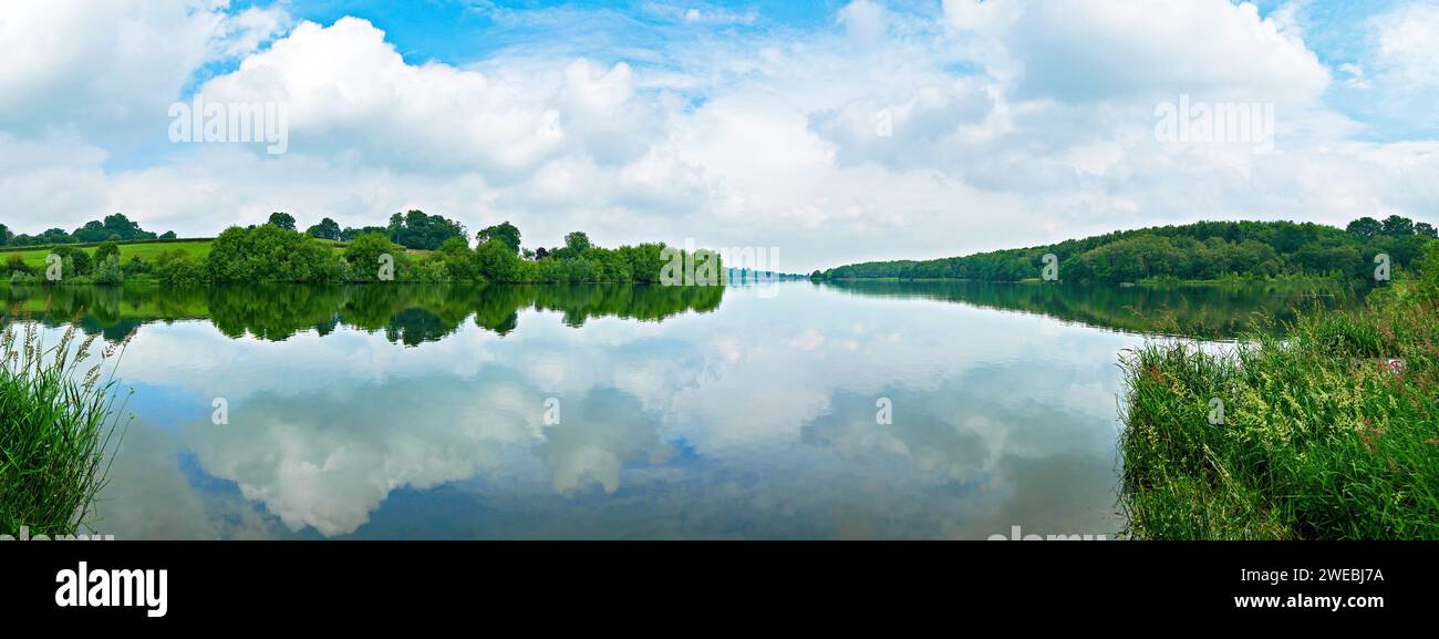 Panoramic view of Staunton Harold Reservoir with still water and reflection of sky in Summer, Derbyshire, England, UK Stock Photo