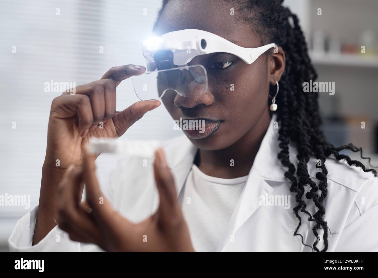 Female Engineer Checking 3D Sample with Magnifying Glasses Stock Photo