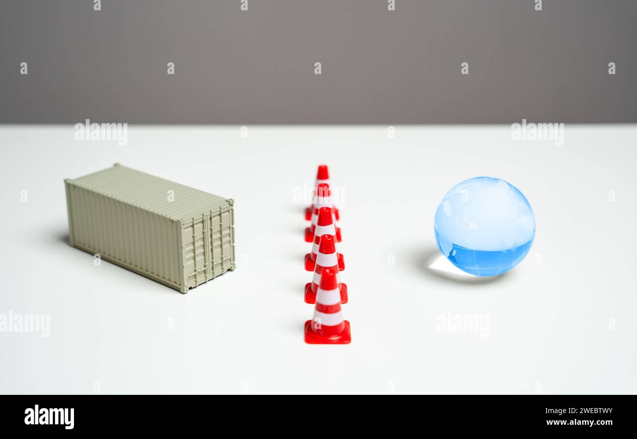 Export restrictions. The shipping container is separated from the world by traffic cones. Limitations on the global movement of goods, trade dynamics Stock Photo