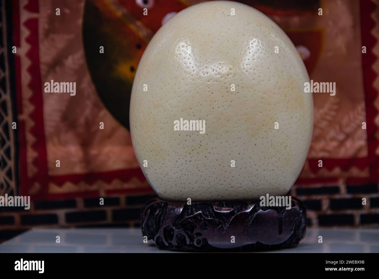 Ostrich big size egg placed on wooden stand, isolated Stock Photo