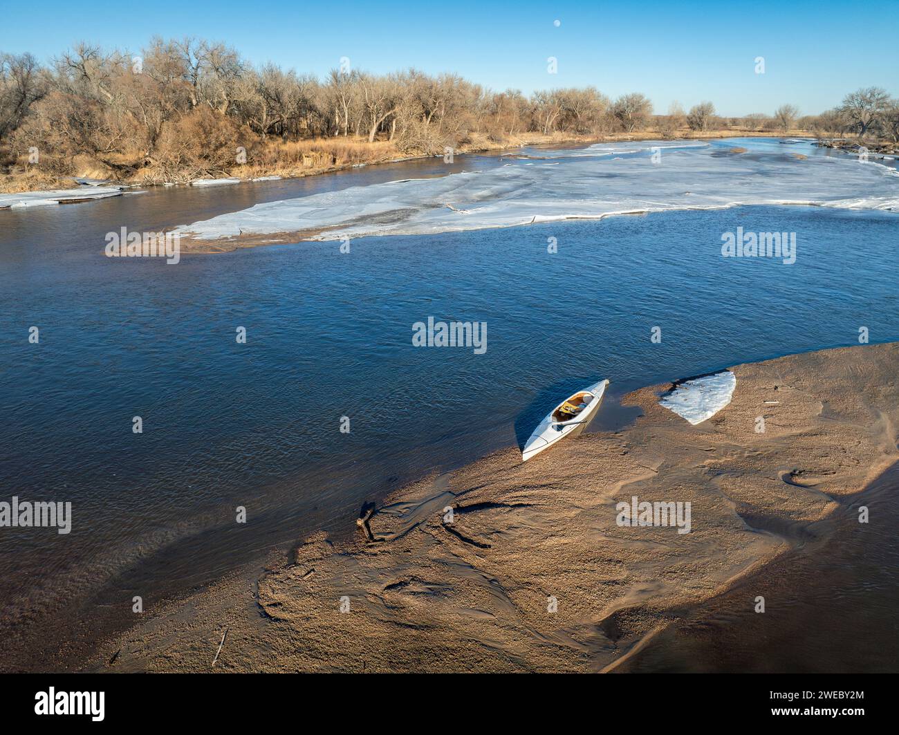 decked expedition canoe on a sandbar with ice floe - South Platte River 