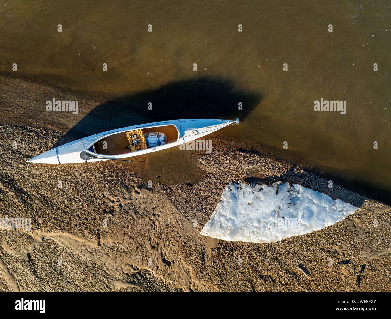 decked expedition canoe on a sandbar with ice floe - South Platte River in eastern Colorado Stock Photo