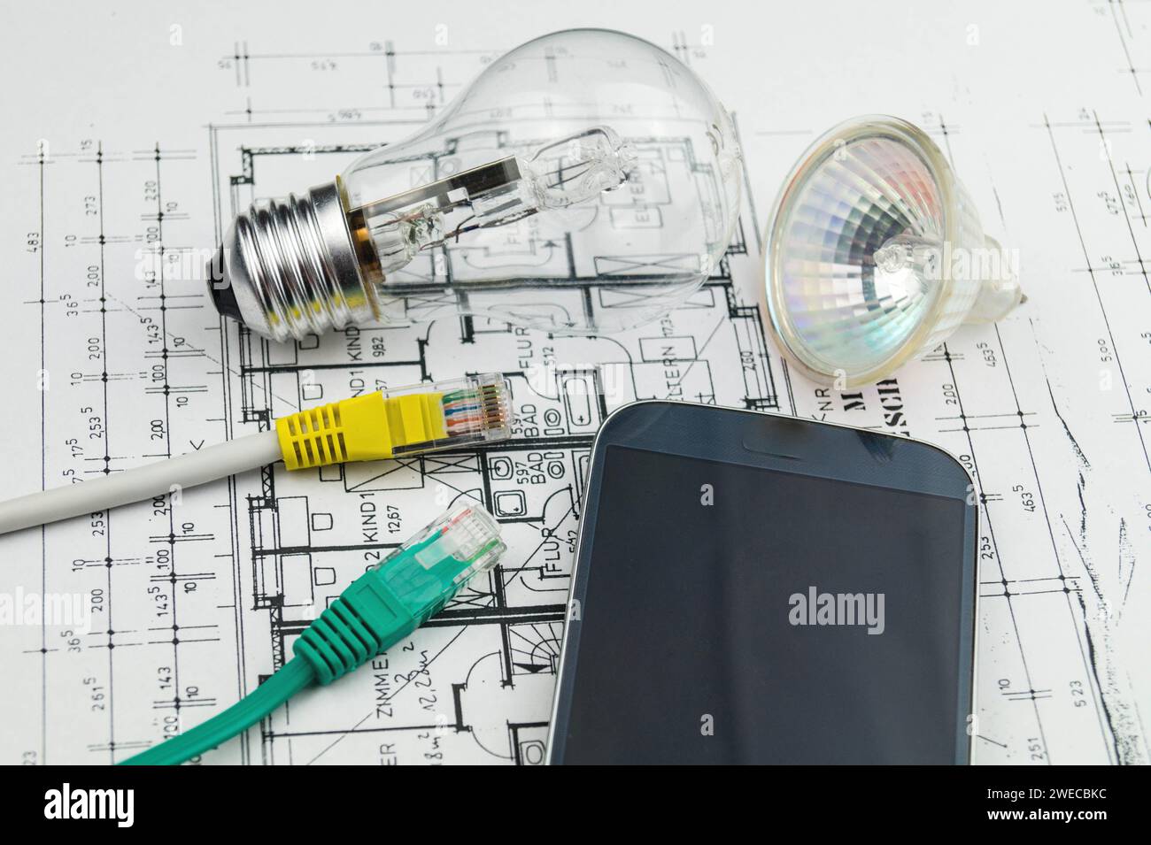 Network plug, lamps and smartphone on construction drawing, symbolic image for Smart Home Stock Photo