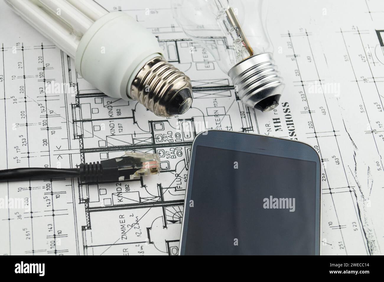 Network plug, lamps and smartphone on construction drawing, symbolic image for Smart Home Stock Photo