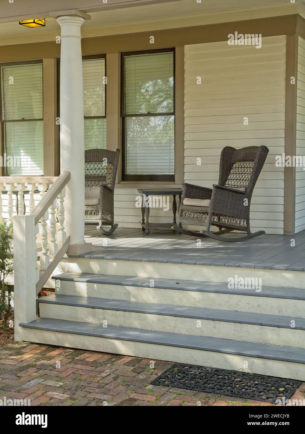 Wicker rocking chairs on front porch of under dappled light Stock Photo