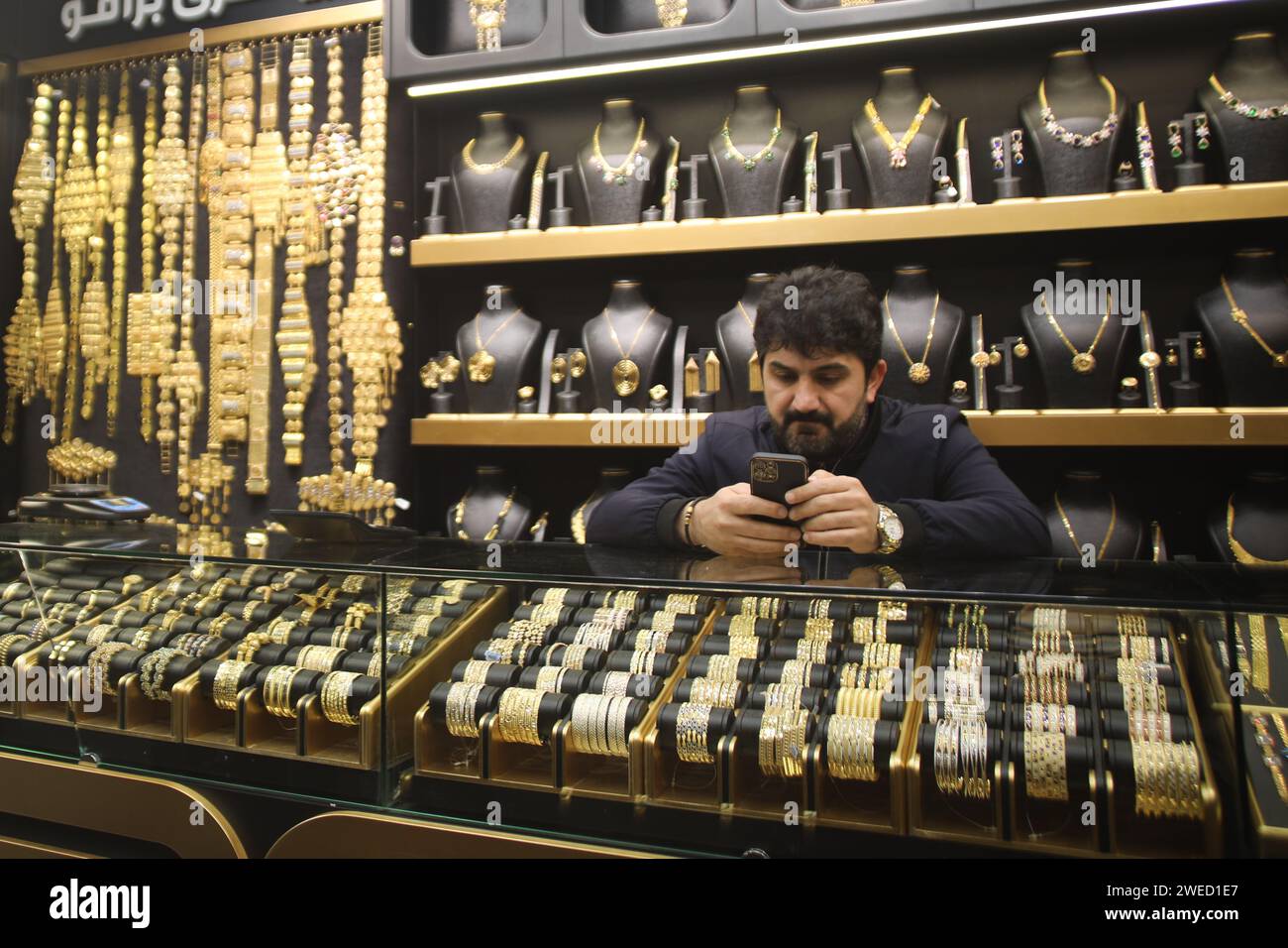 Erbil, Iraq. 24th Jan, 2024. A vendor waits for customers at a gold ...