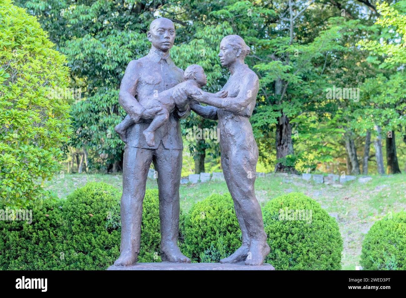 Bronze statue of Japanese man, woman and child in nature park. Artist unknown Stock Photo