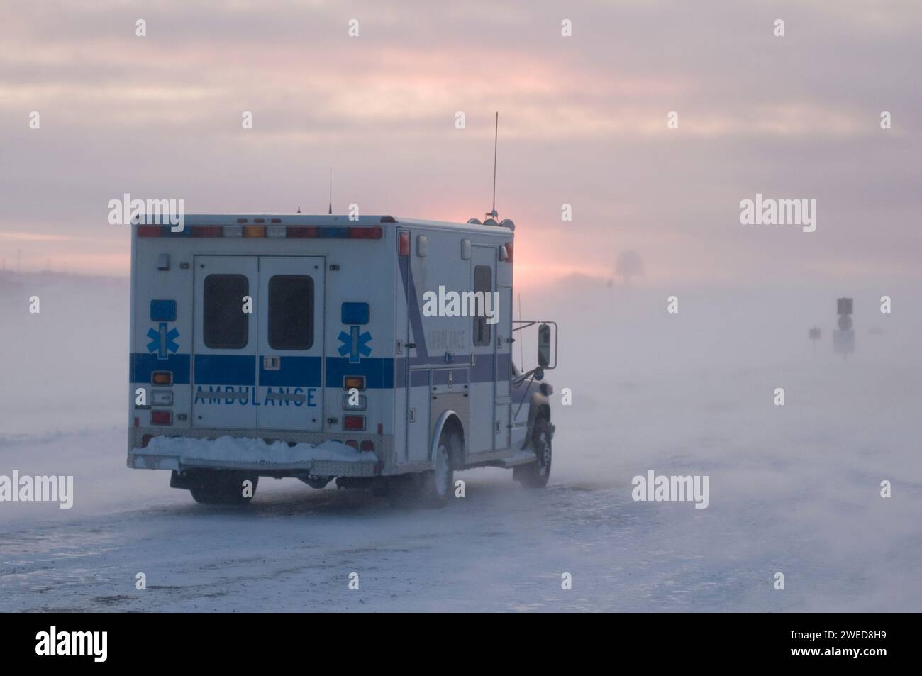 Ambulance drives through the Inupiaq village of Kaktovik during a blizzard at sunset, Barter Island, 1002 area of the Arctic National Wildlife Refuge, Stock Photo