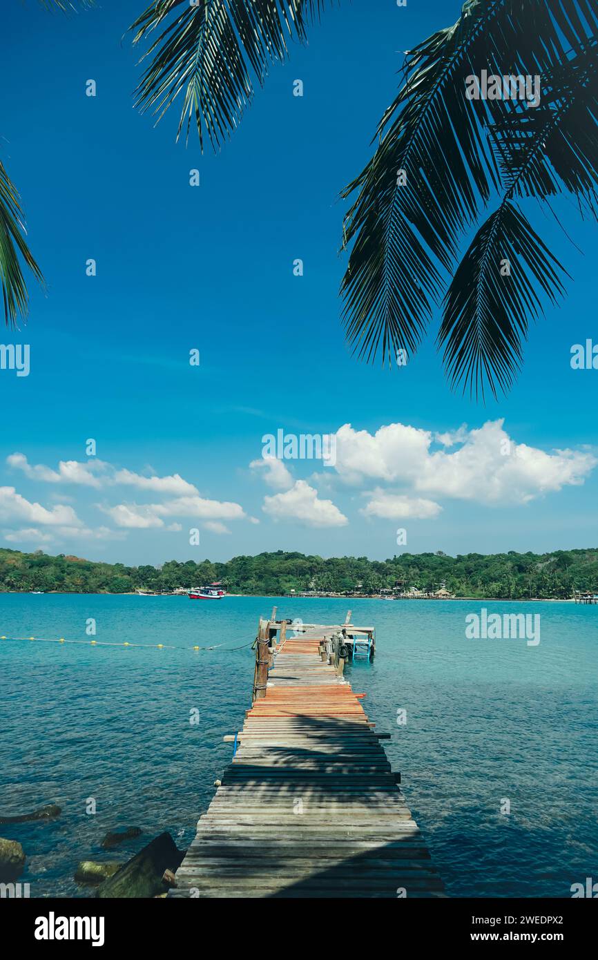 Long wooden bridge go to the sea in beautiful tropical island. Tranquil panoramic landscape. Wooden pier at Bang Bao Beach Koh Kood Island Thailand Tr Stock Photo