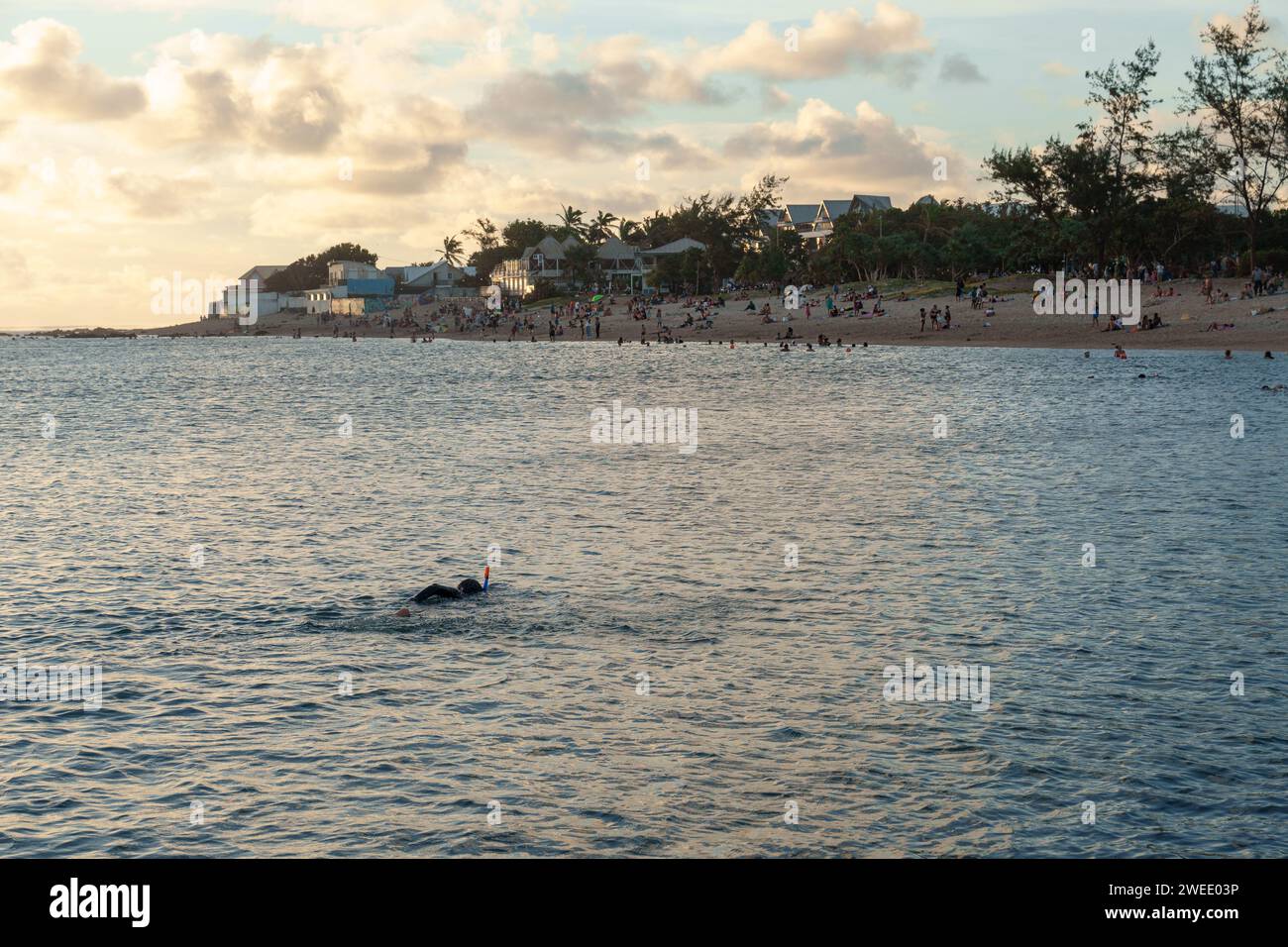 A swimmer in the lagoon of Saint-Pierre, Réunion Island, wearing a mask and snorkel, at sunset. Stock Photo