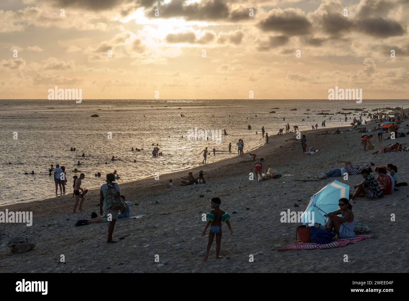The beach at Saint-Pierre lagoon, Réunion Island, at sunset. Tourists, family and people enjoying the scenic view. It's a popular travel destination Stock Photo