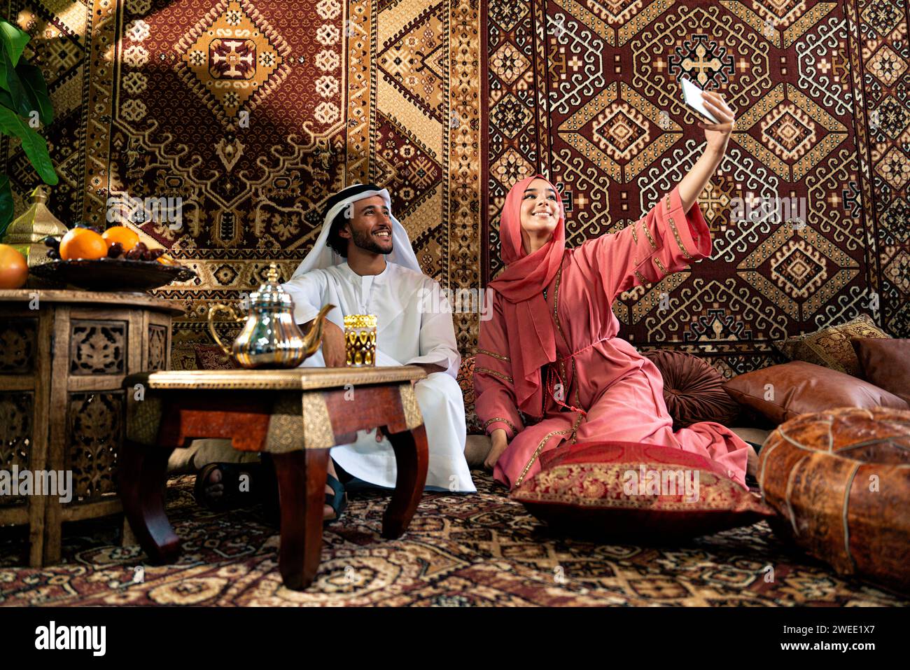 Young couple from Emirati spending time in an arabian traditional cafe ...