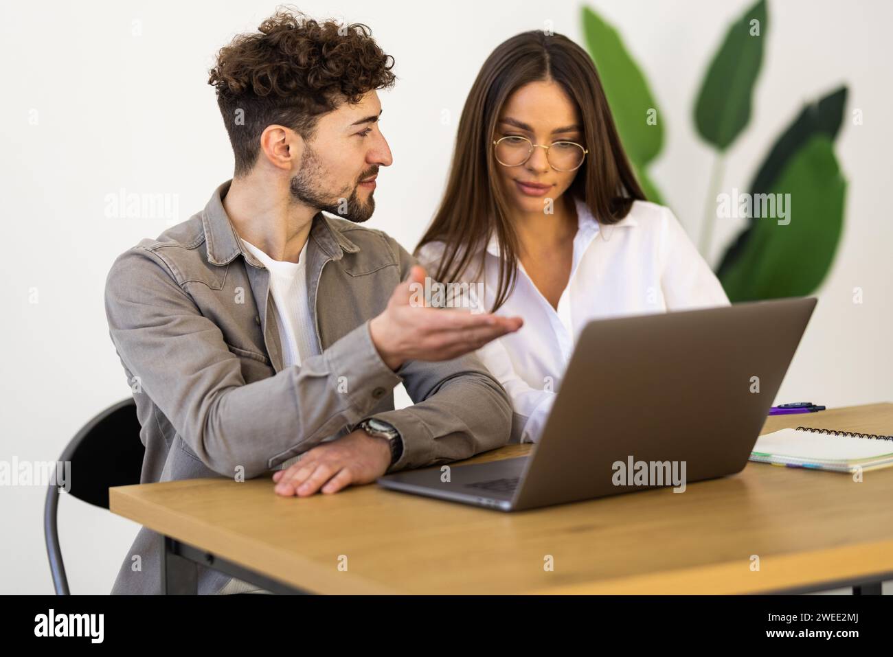 Businessman and businesswoman working with laptop at modern office Stock Photo