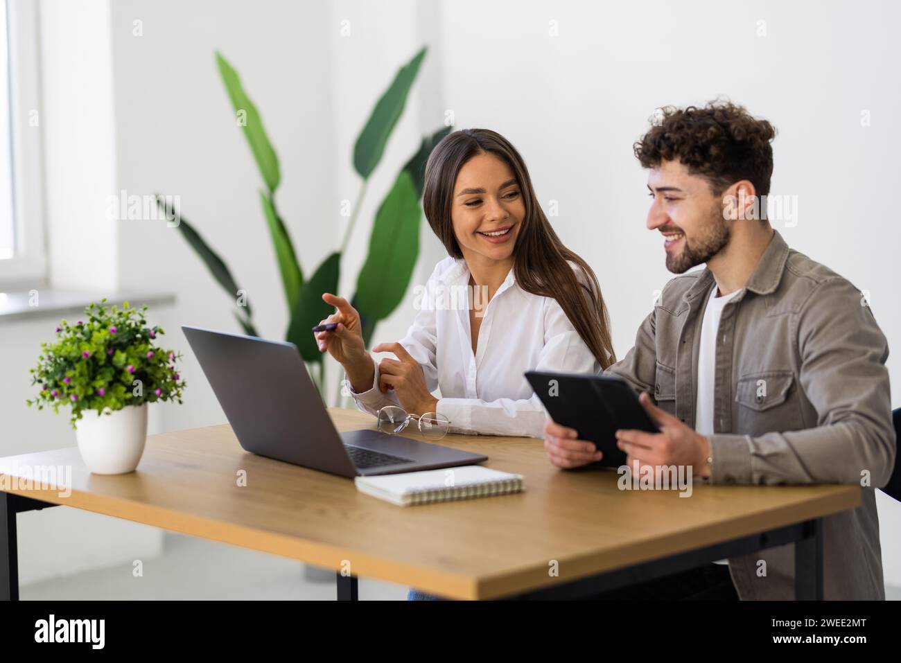 Busy couple working at the office doing business together Stock Photo