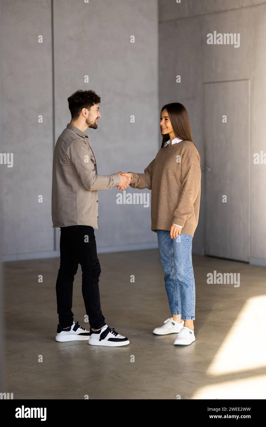 Young business couple handshaking in the office Stock Photo