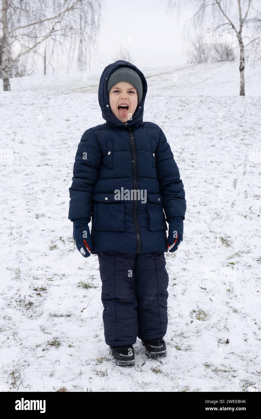 Cute Little Funny Kid Boy In Colorful Winter Fashion Clothes Having Fun And  Playing With Snow Outdoors During Snowfall Stock Photo - Download Image Now  - iStock