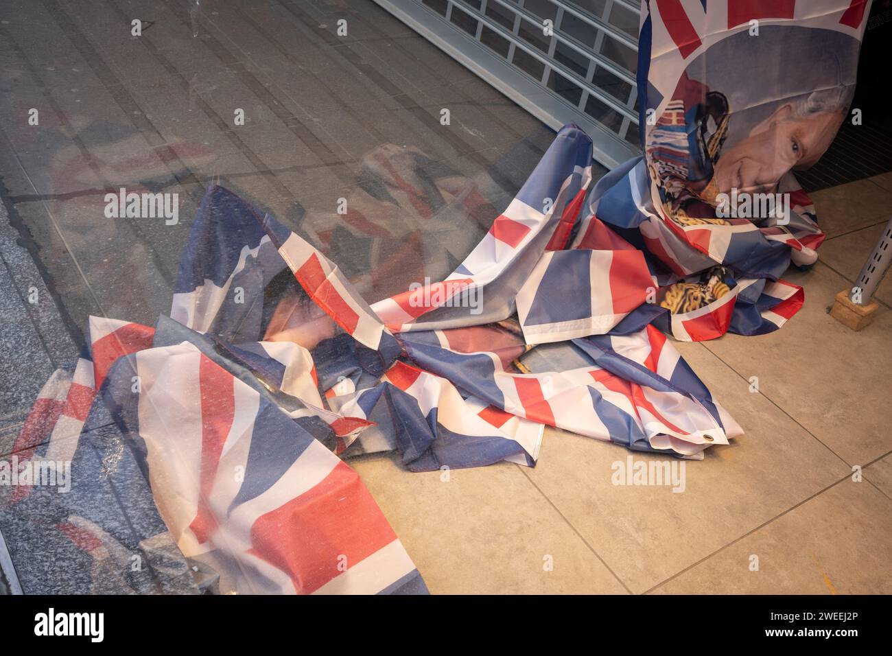 The fallen faces of King Charles III seen on flags that have been used to cover the window frontage of a closed retail business on Oxford Street, on 24th January 2024, in London, England. Stock Photo