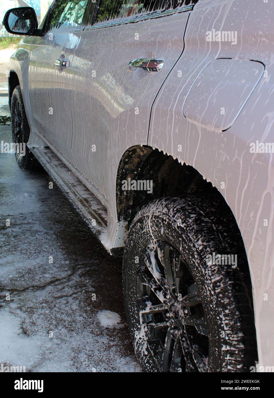 Vehicle After Off Road Driving  Is Treated With Cleaning Foam At A Car Wash Stock Photo