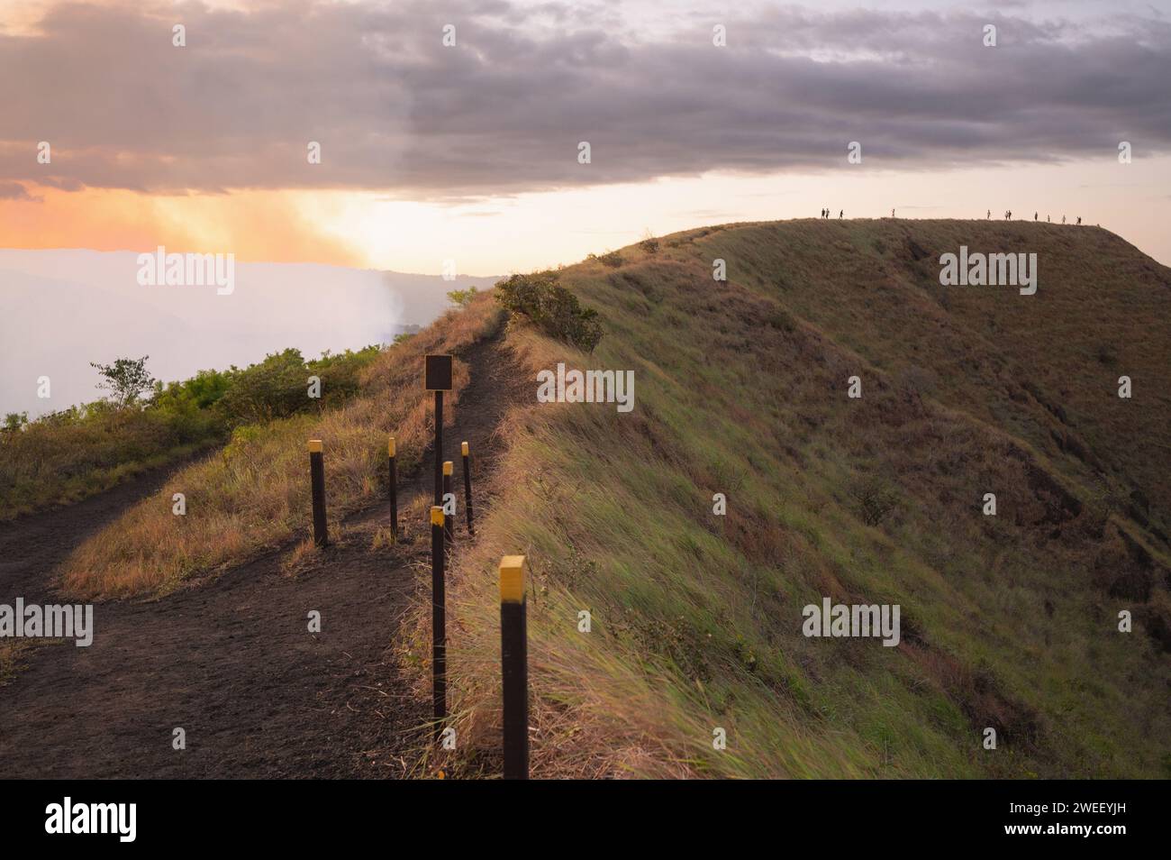 Hiking trekking trail path on mountain volcano peak with walking silhouette people Stock Photo