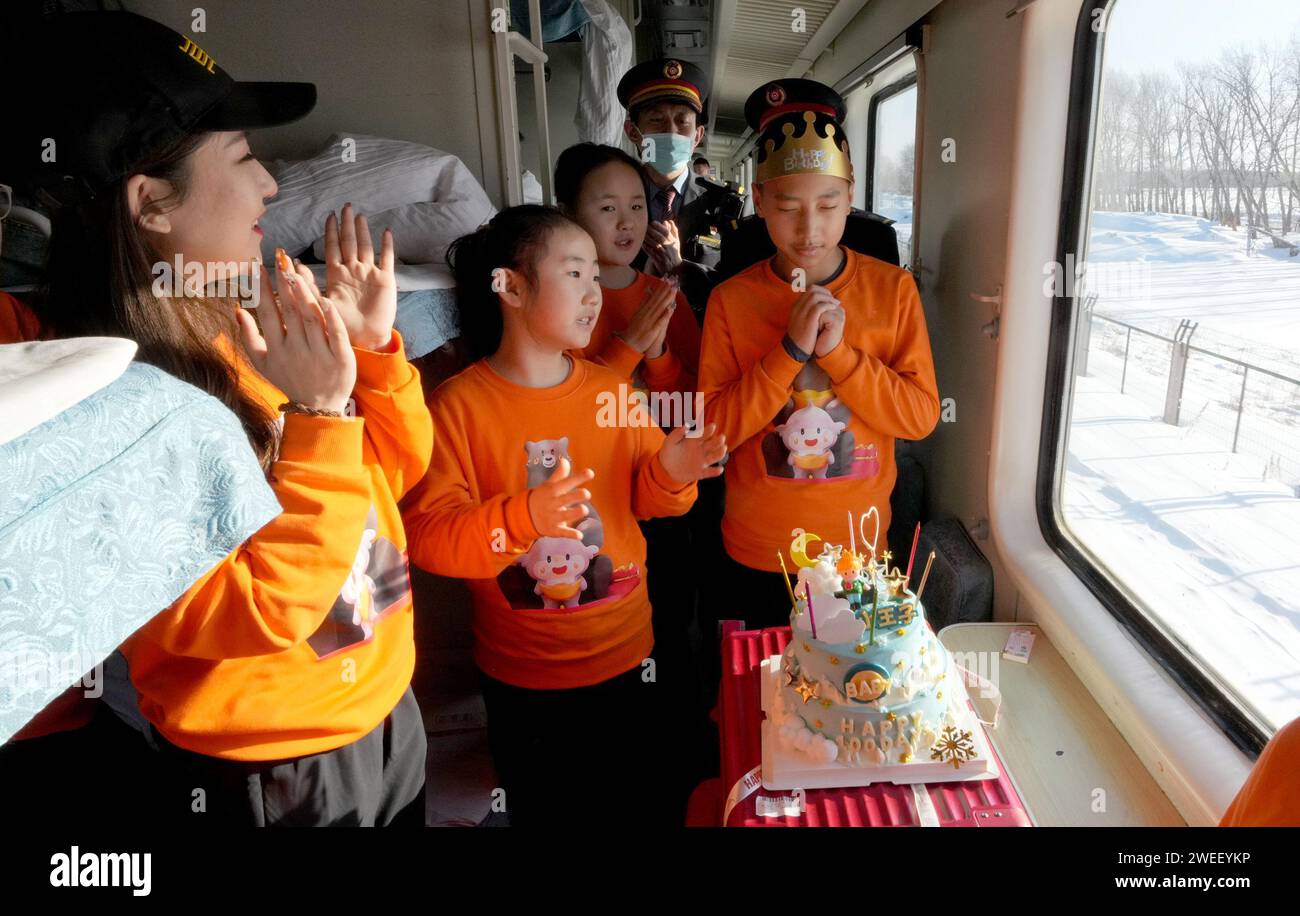 Harbin. 23rd Jan, 2024. A student celebrates his birthday on the train K7065 from Harbin to Fuyuan in northeast China's Heilongjiang Province, Jan. 23, 2024. The train K7065/K7066 travels to and fro between the city of Harbin and Fuyuan in China's northeastern province of Heilongjiang. With a single journey time of nearly 15 hours, the train replaced old carriages with new ones having air conditioning system, offering a better travel experience for locals who visit friends or commute to work or study along the line. Credit: Wang Yuguo/Xinhua/Alamy Live News Stock Photo