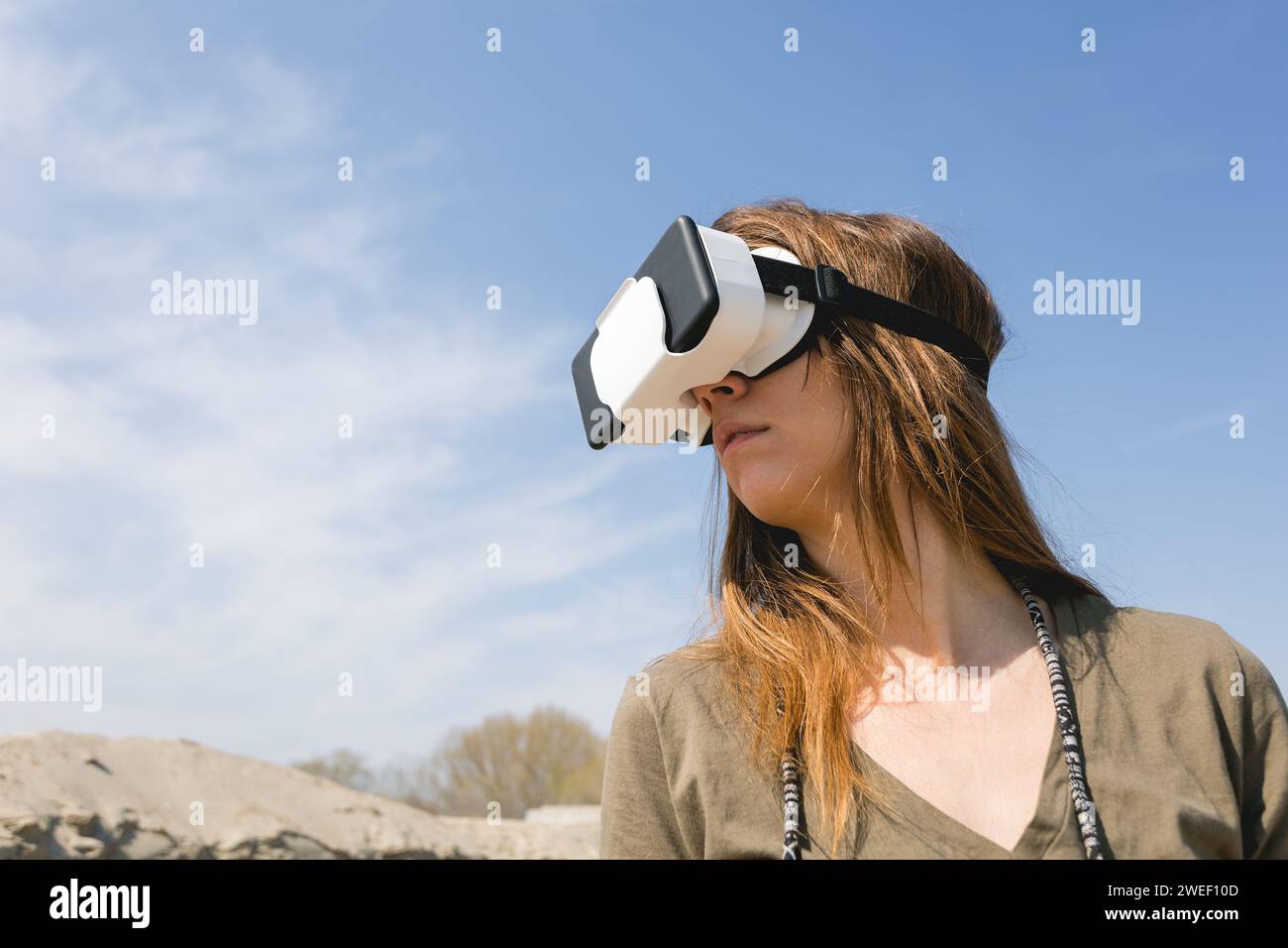young woman wearing virtual reality goggles outdoors Stock Photo
