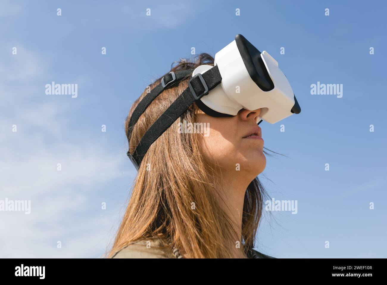 young woman wearing virtual reality goggles outdoors Stock Photo