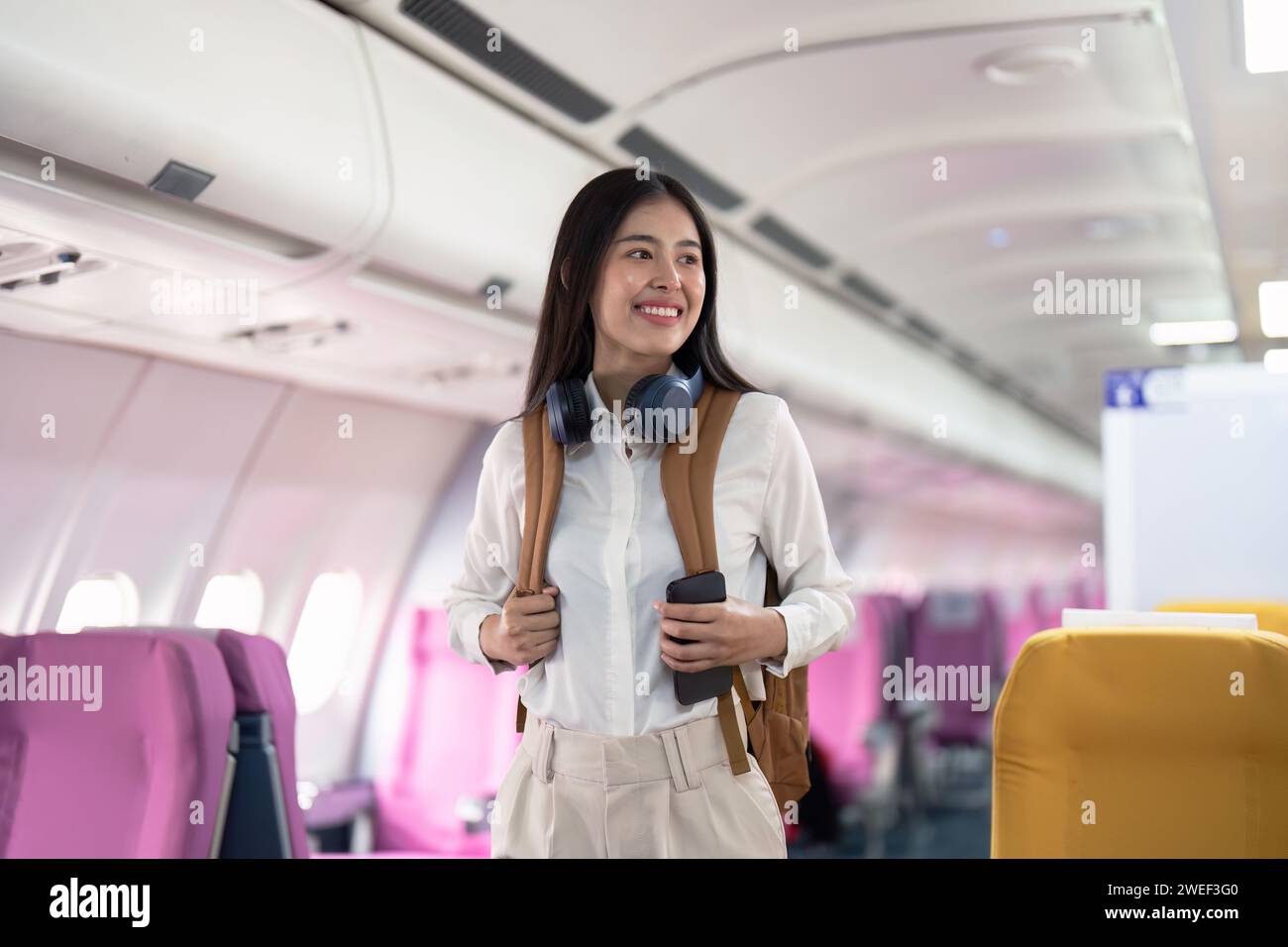 Alone Asian woman passenger traveling by plane. happy traveler on board. Solo travel concept Stock Photo