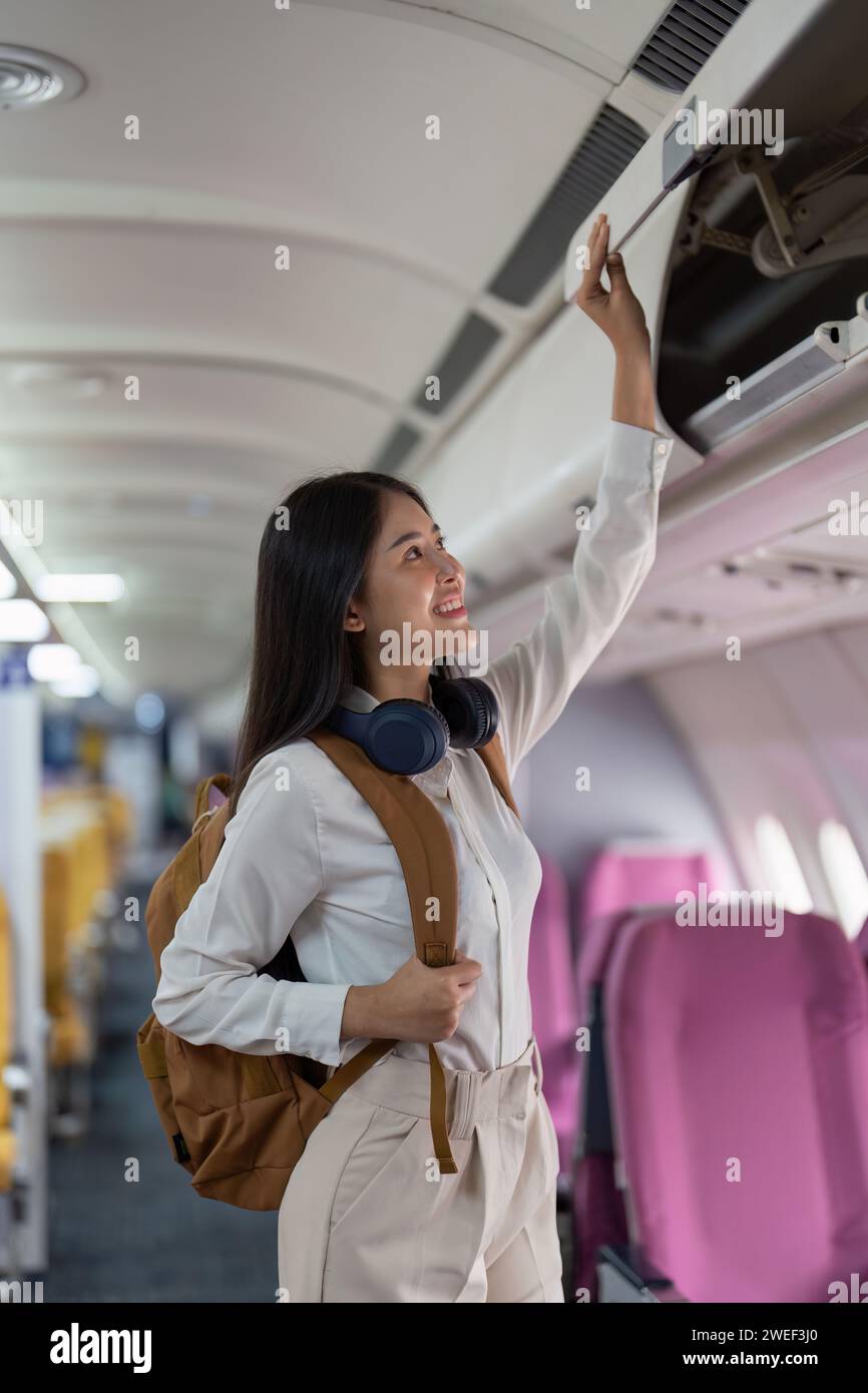 Alone Asian woman passenger traveling by plane. happy traveler on board. Solo travel concept Stock Photo