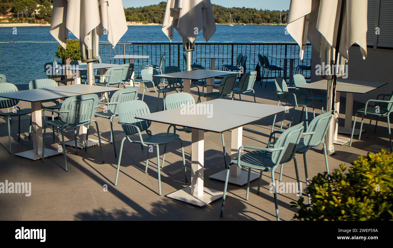 empty restaurant tables next to ocean Stock Photo