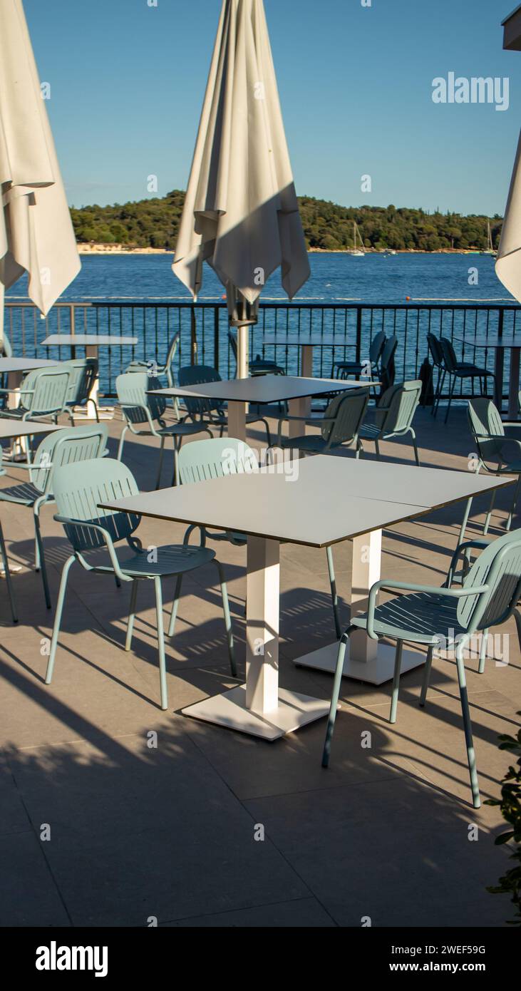 empty restaurant tables next to sea Stock Photo