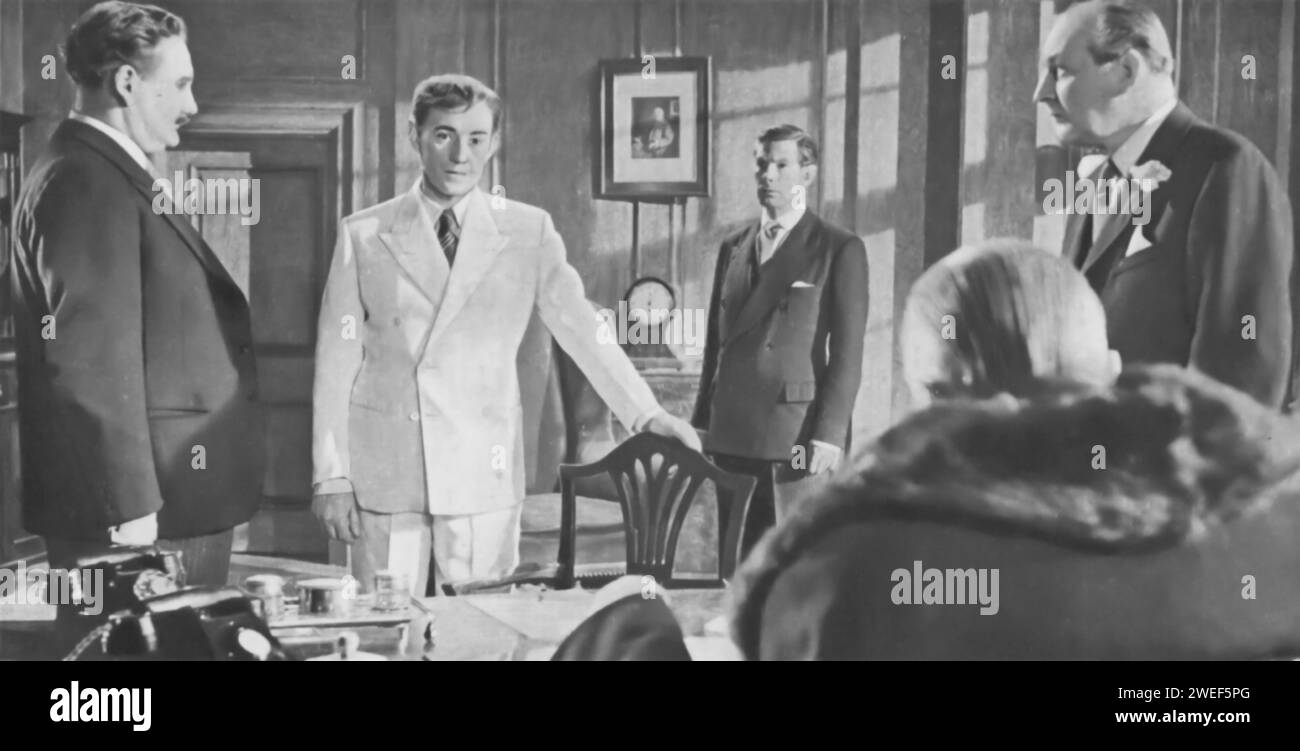 Howard Marion-Crawford, Alec Guinness, Michael Gough, Ernest Thesiger, and Cecil Parker star in 'The Man in the White Suit' (1951), a British satirical comedy. Alec Guinness plays Sidney Stratton, an eccentric chemist who invents an indestructible and dirt-repelling fabric, which disrupts the textile industry. Parker portrays Alan Birnley, a mill owner, Gough is Michael Corland, a rival manufacturer, Thesiger plays Sir John Kierlaw, and Marion-Crawford appears as Cranford, a supportive lab technician. Stock Photo