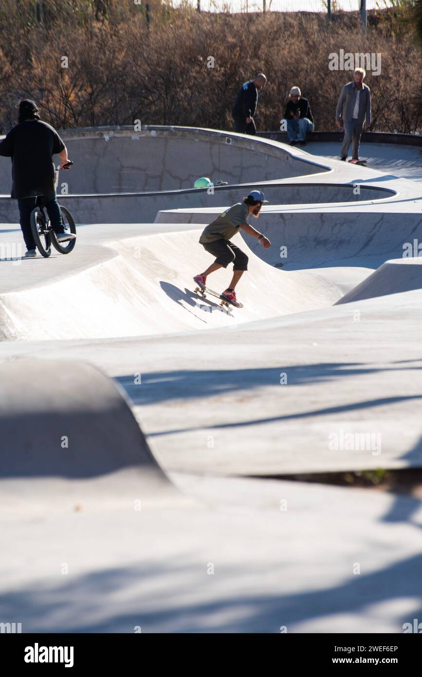 Diverse skate culture: Boy skater embraces the vibrant energy of a dynamic skate park gathering Stock Photo