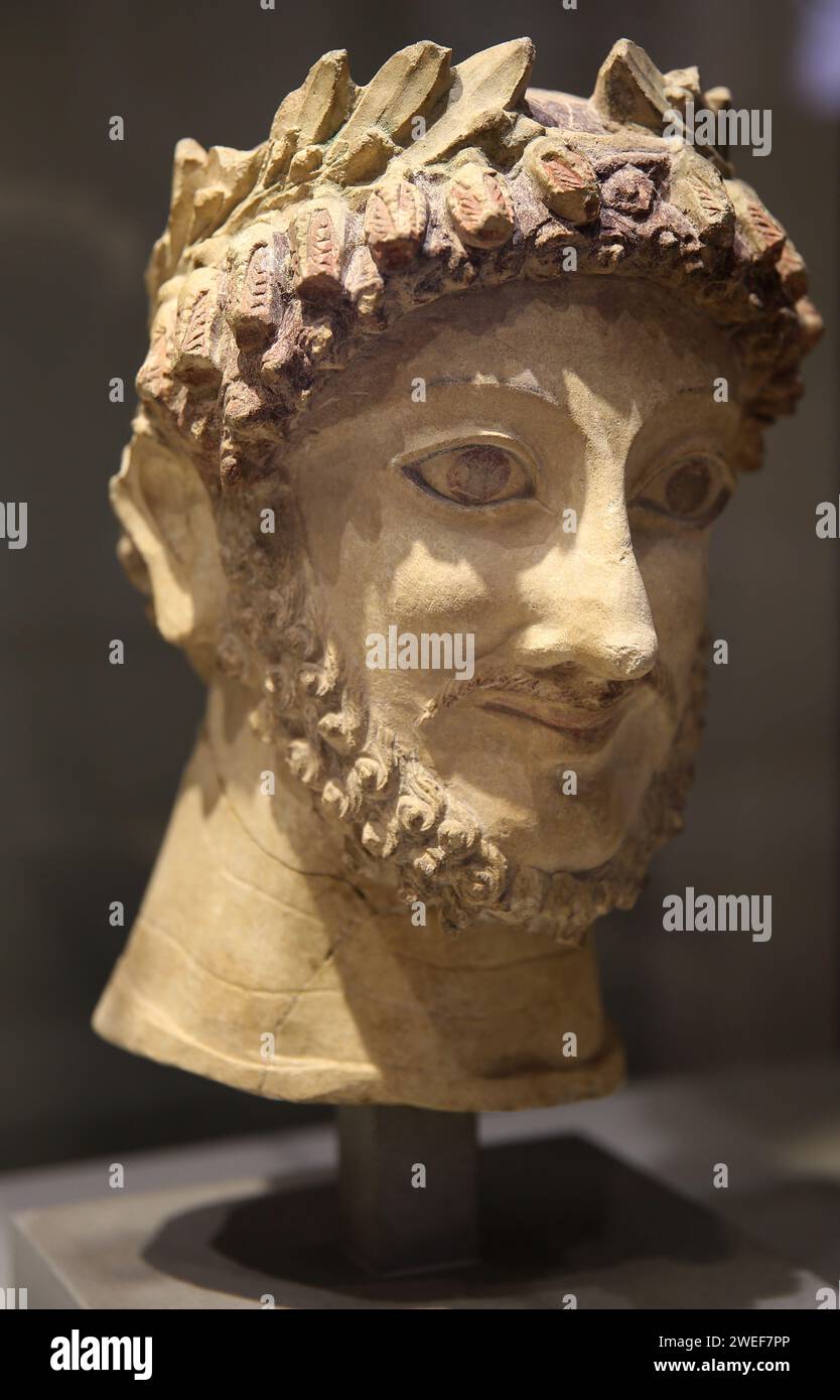 Sculpture with polychrome traces. Head with a laurel wreath of an Aphrodite priest. ca. 500 BC, from Athienous, Cyprus island. Museum Barracco. Rome. Stock Photo