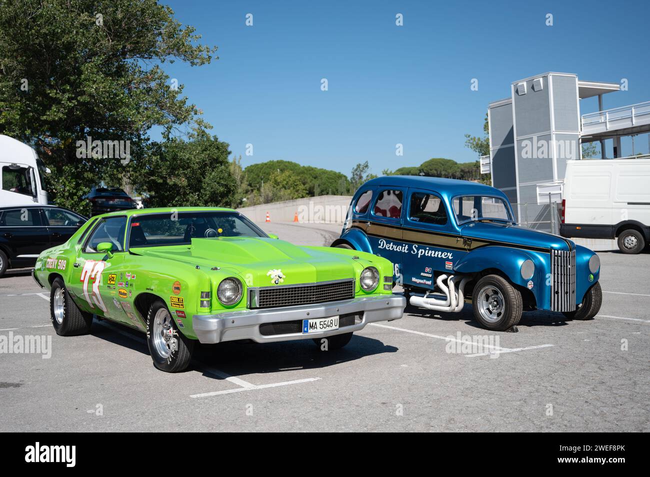 impressive green second-generation Chevrolet Montecarlo American muscle car prepared for quarter-mile acceleration races next to a dragster Stock Photo