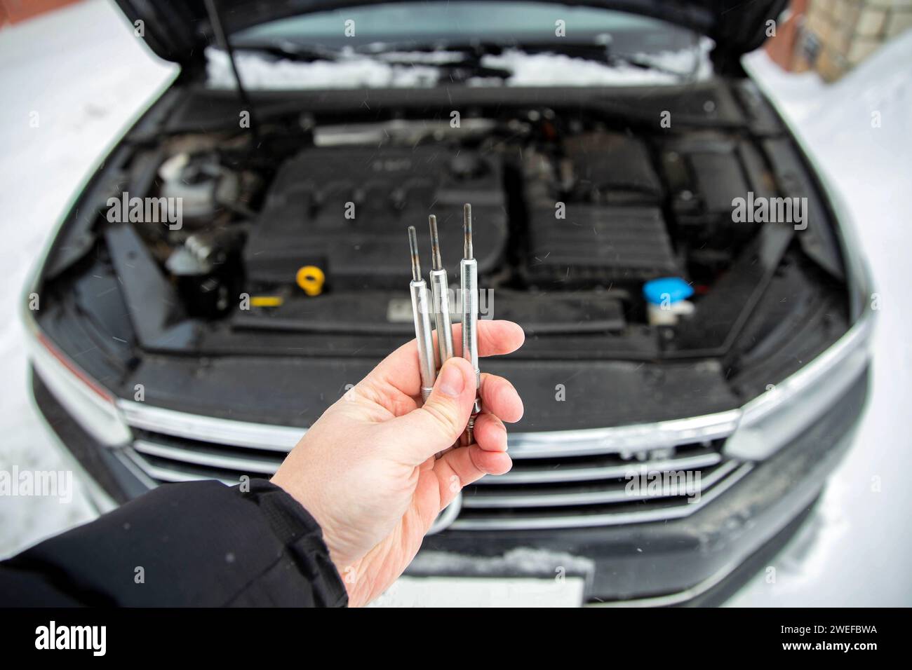 Modern ceramic glow plugs in hand against the background of a diesel