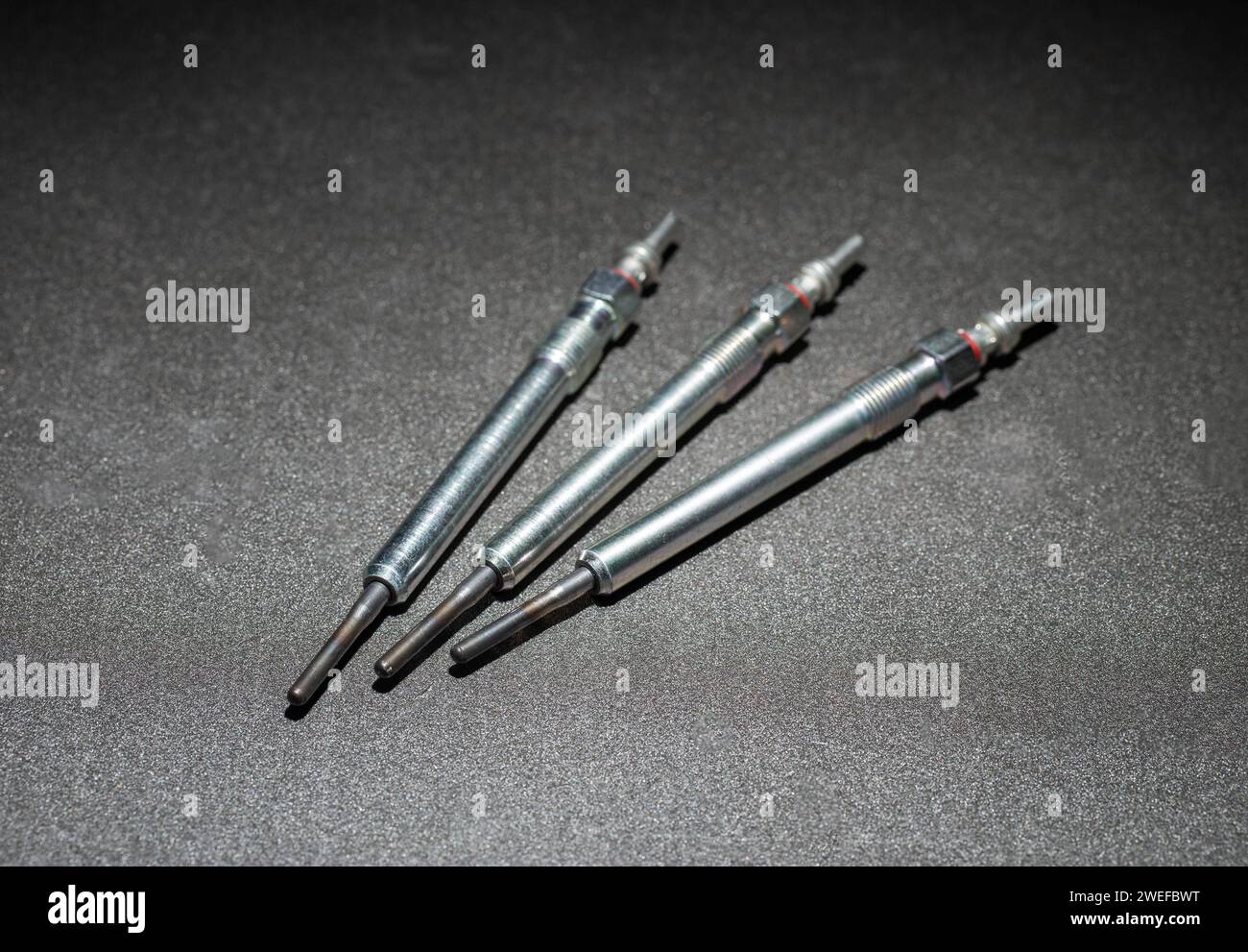 Modern rod ceramic glow plugs for easier starting of a diesel engine in cold weather on a gray background. Automotive spare part, heating element, eng Stock Photo