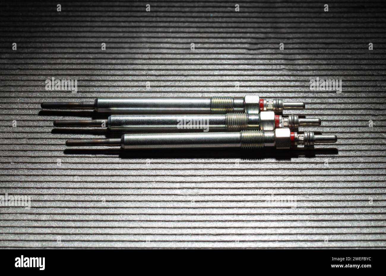 Modern rod ceramic glow plugs for easier starting of a diesel engine in cold weather on a gray background. Automotive spare part, heating element, eng Stock Photo