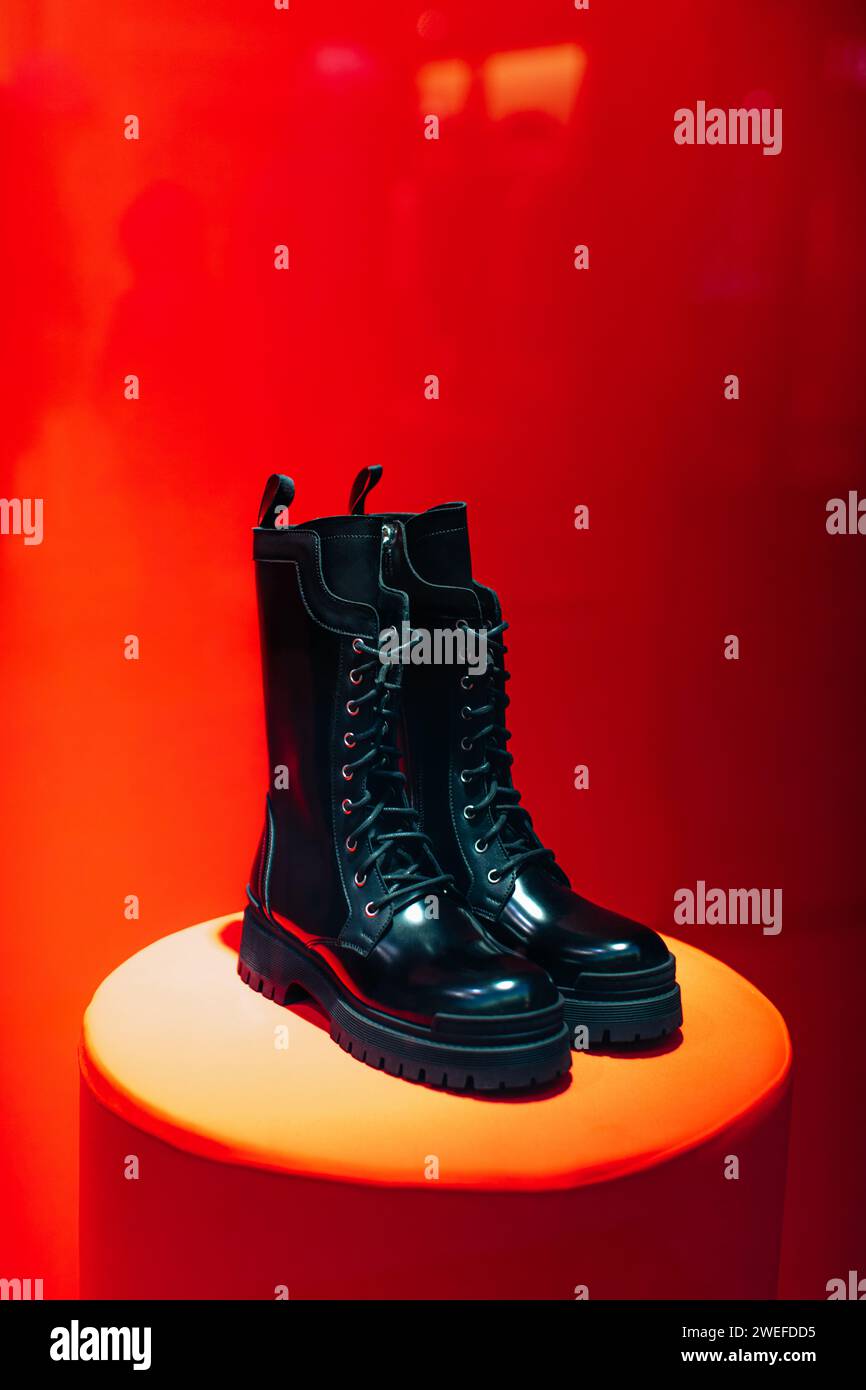 Black women's patent leather lace-up shoes on a boutique stand on a red ...