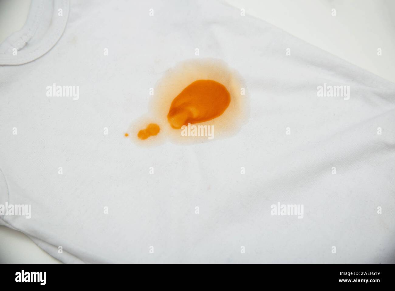 Orange stains on children's clothes from fruit puree. The concept of