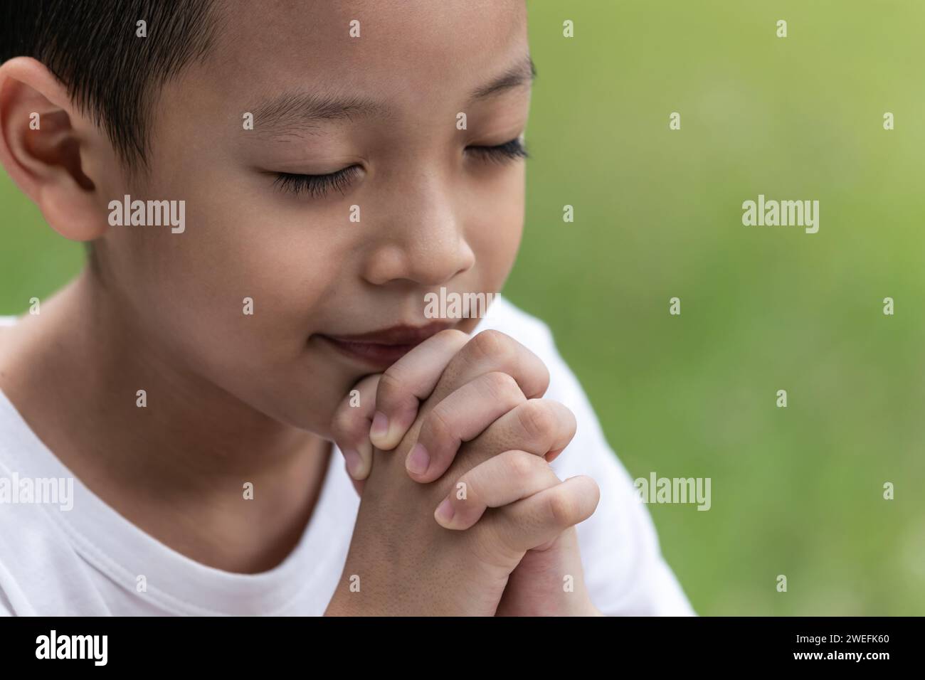Little boy with Bible praying and close your eyes in praying. Prayer to