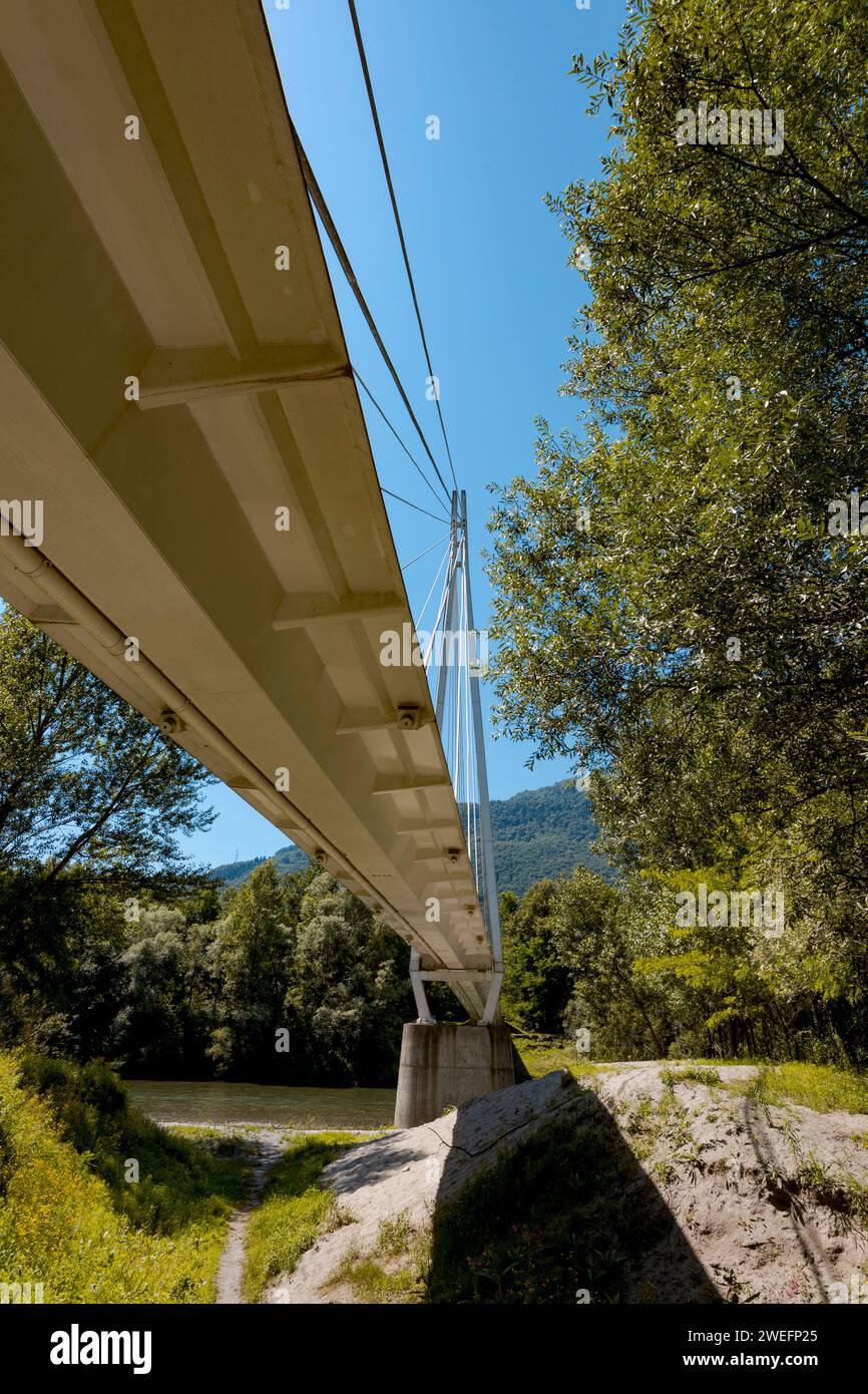 Pedestrian bridge in the middle of the forest, beautiful architecture and great engineering. The bridge is embedded in the Swiss Alps. View from the b Stock Photo