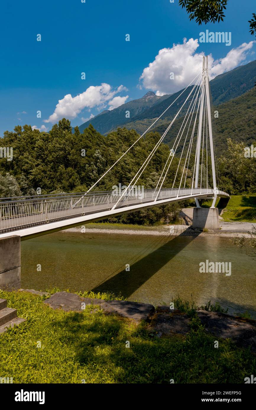 Modern pedestrian bridge in the middle of the mountains of Italian Switzerland, which allows you to cross the Ticino river. Beautiful sunny summer day Stock Photo