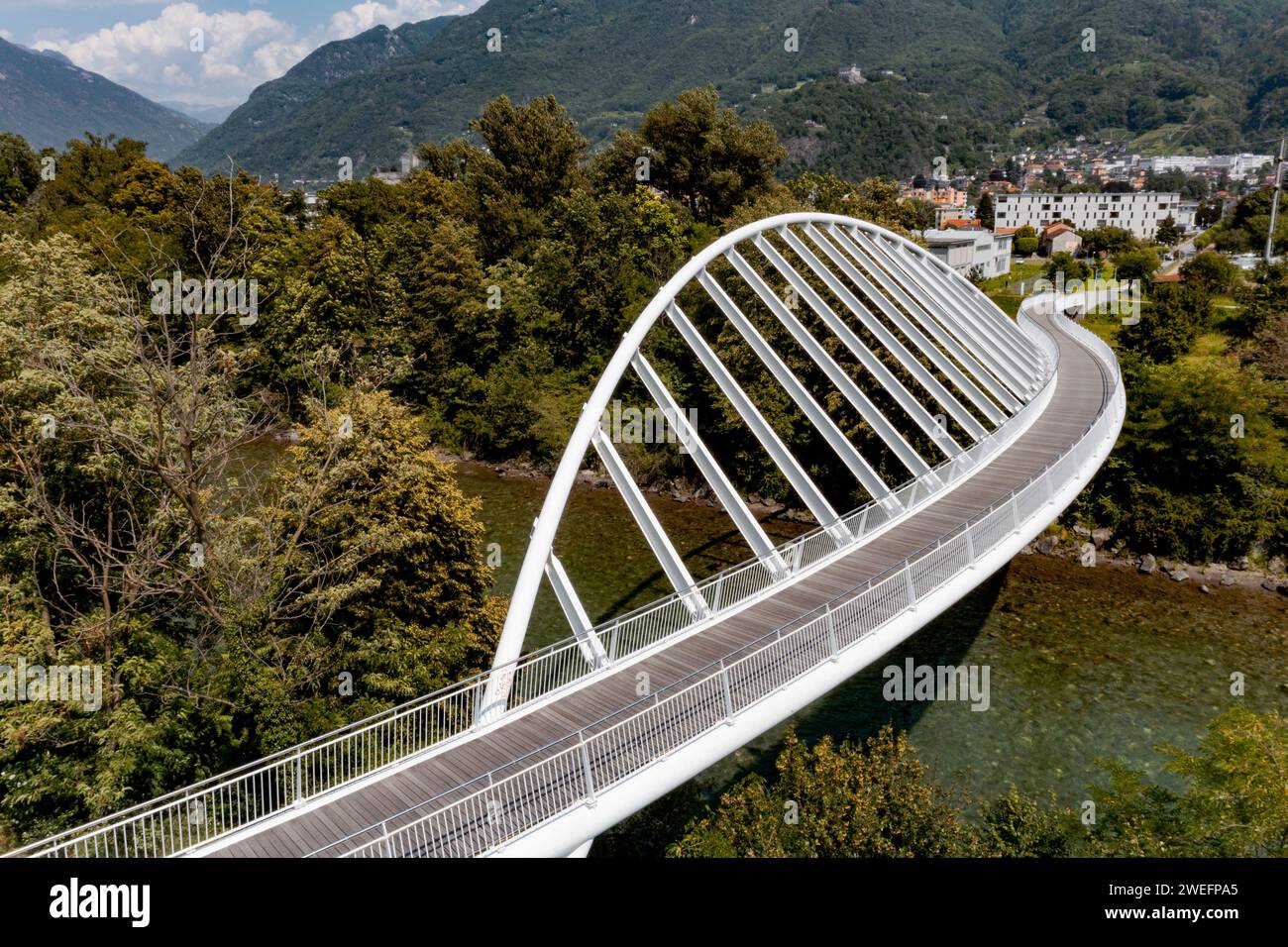 Aerial view of a modern arch shaped design pedestrian bridge over the Ticino river in Switzerland. Nobody inside Stock Photo