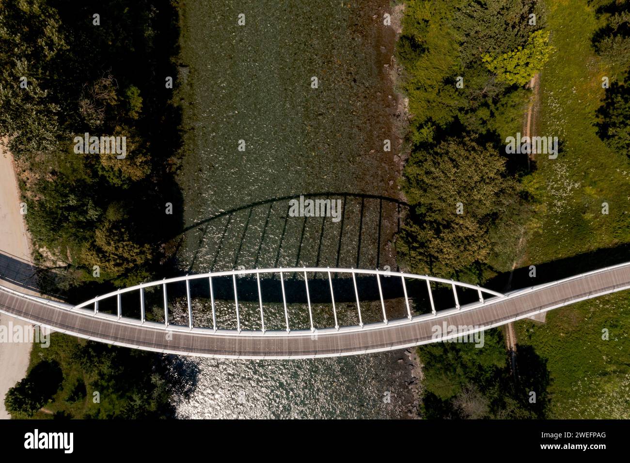 Zenith view of a modern arch shaped design pedestrian bridge over the Ticino river in Switzerland. Nobody inside Stock Photo