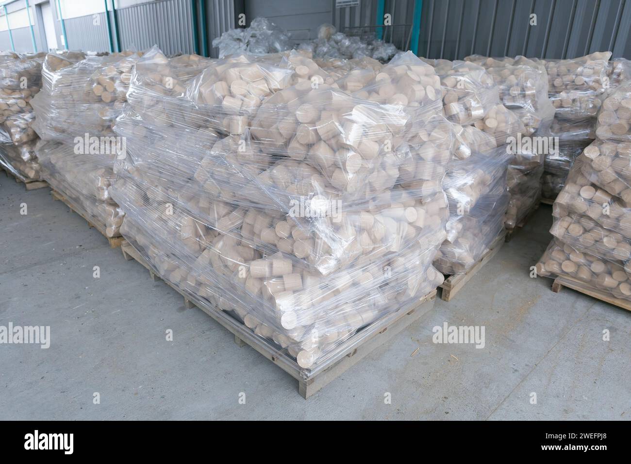 wooden heating briquettes stacked for distribution Stock Photo
