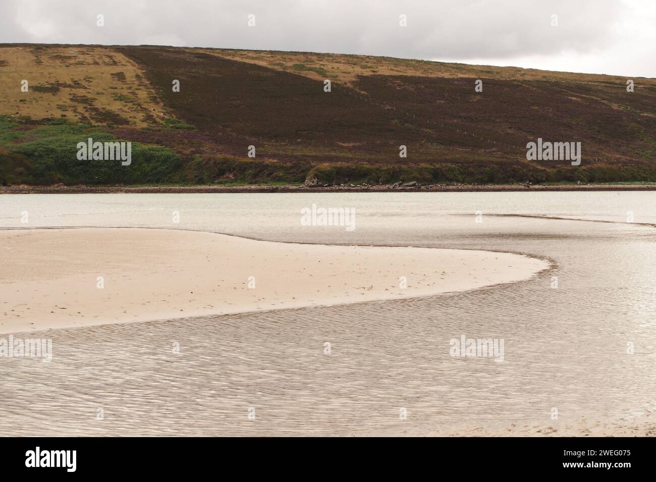 The sea waters at Waulkmill Bay, Orkney, Scotland, UK receding at low tide leaving sand and water curves on the beach Stock Photo