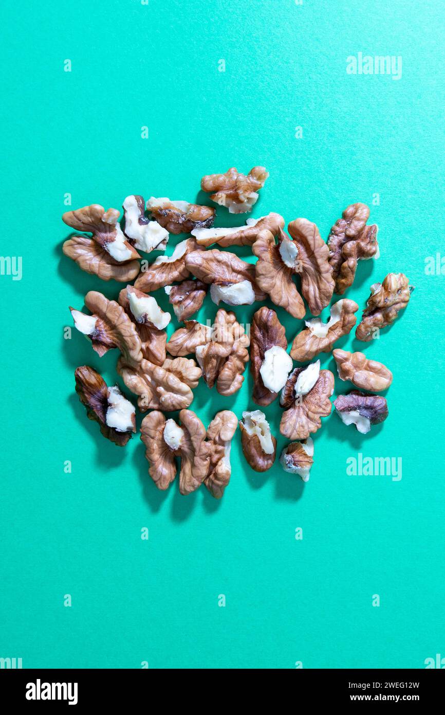 crashed walnuts isolated on green background Stock Photo