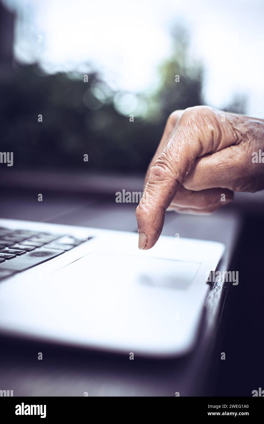 old persons finger on laptop keyboard Stock Photo