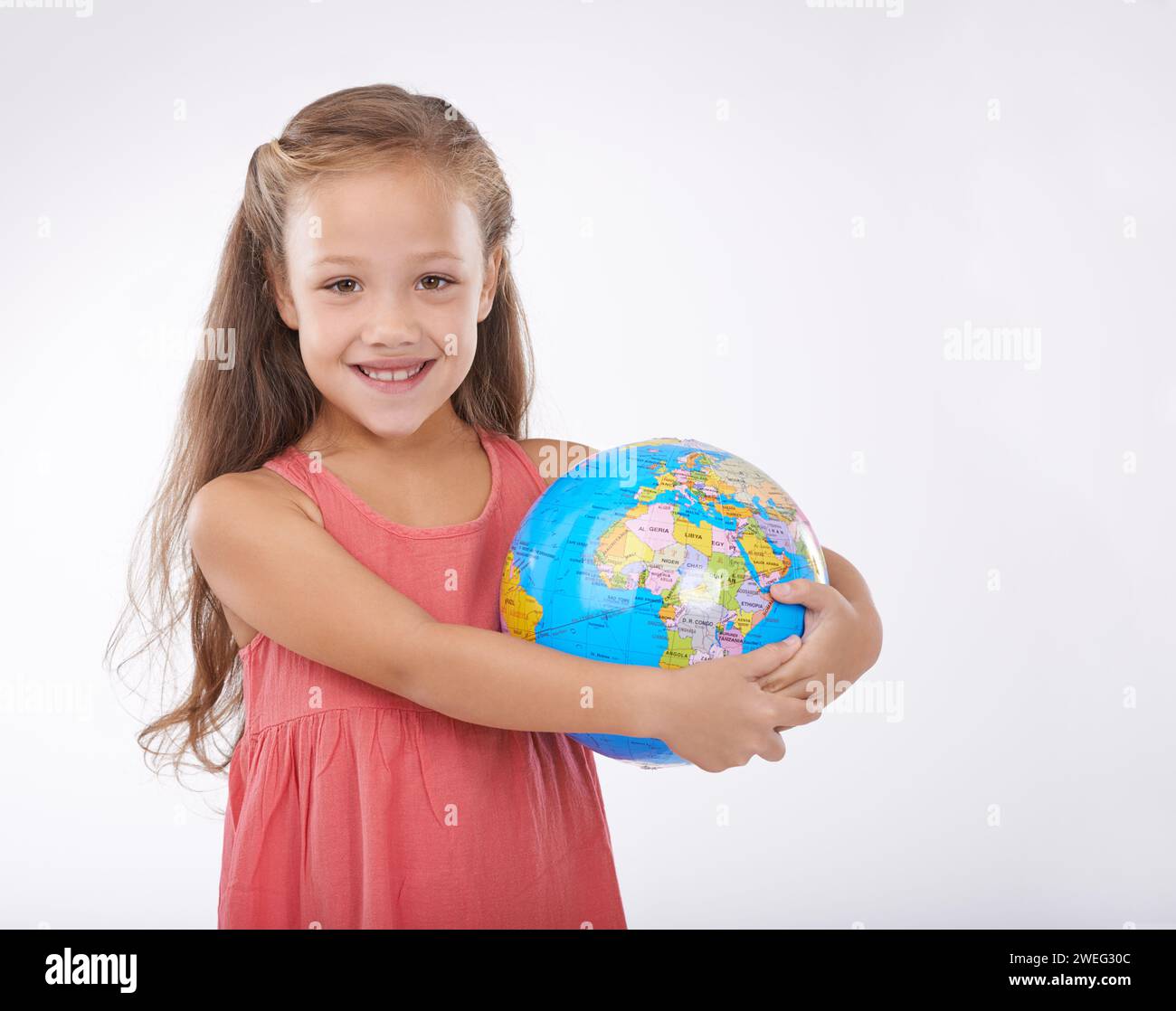 Child, portrait and world globe for education school learning in studio for Geography, continents or white background. Girl, student and planet for Stock Photo